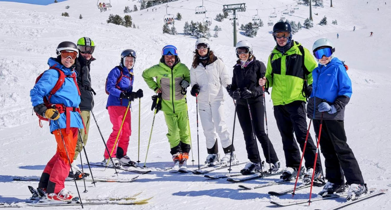 Grupo de alumnos sonriendo en Baqueira con logo de Reverse Ski School integrado